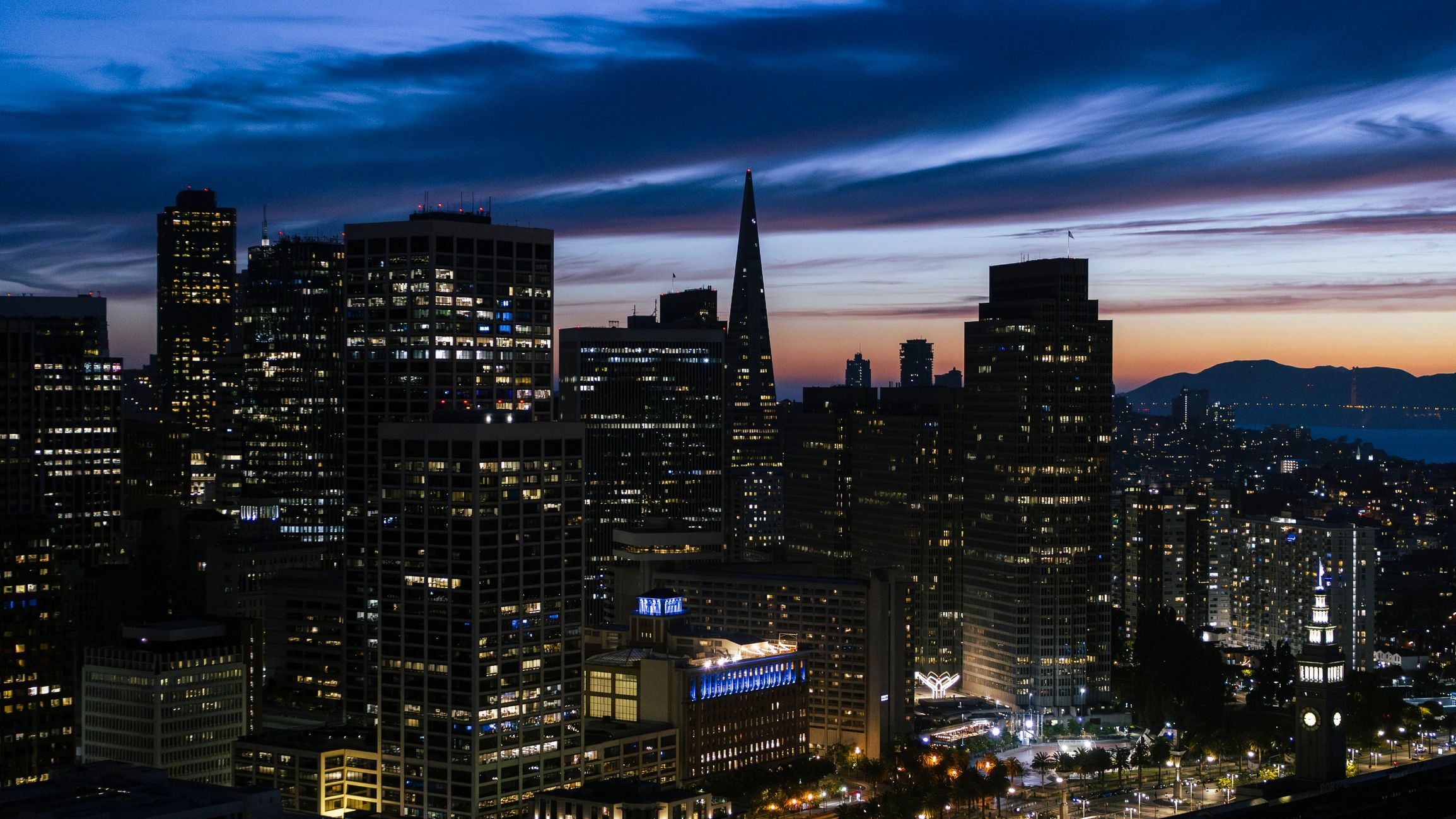 Financial district skyline at sunset representing executive travel and urban exposure